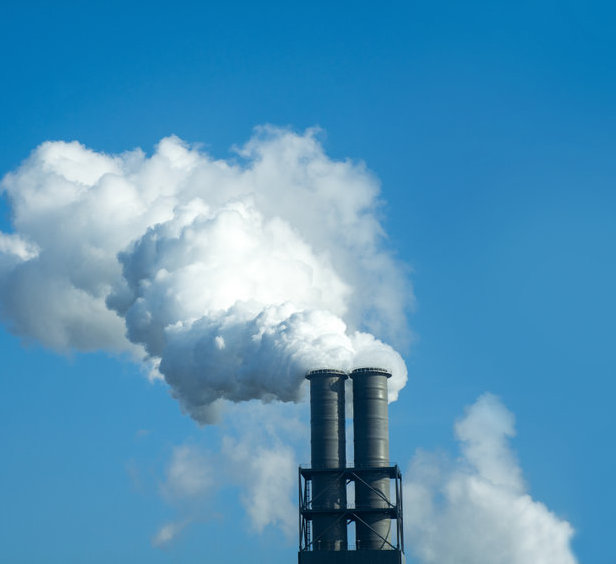 chimney with industrial smoke against blue sky